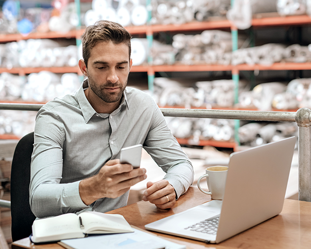 A man with a laptop is in the warehouse