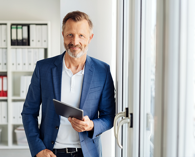 A business man is staying with the tablet