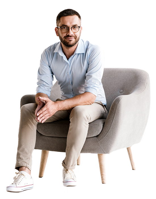 The young man is sitting on the armchair