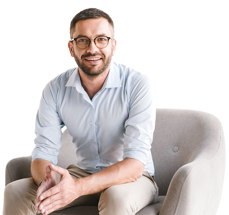 The young man is sitting on the armchair